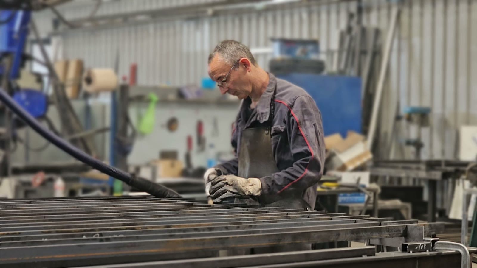 Opérateur préparant de longues barres d'acier dans l'atelier de fabrication Distrifermetures